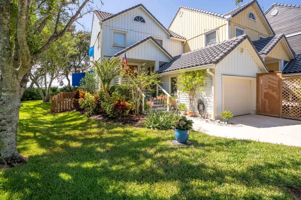 a view of a house with a small yard and sitting area