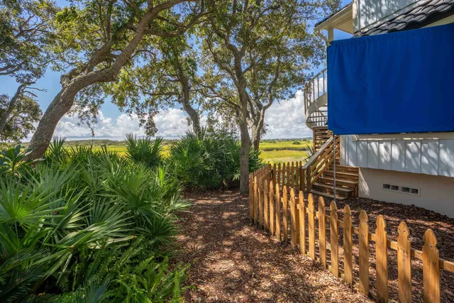 a view of a pathway of a house with large trees