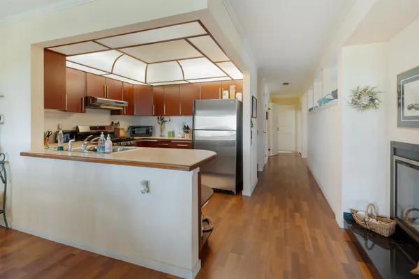 a kitchen with stainless steel appliances a refrigerator a sink a stove and white cabinets