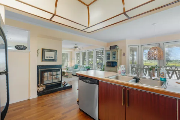 a room with stainless steel appliances granite countertop a sink and wooden floors