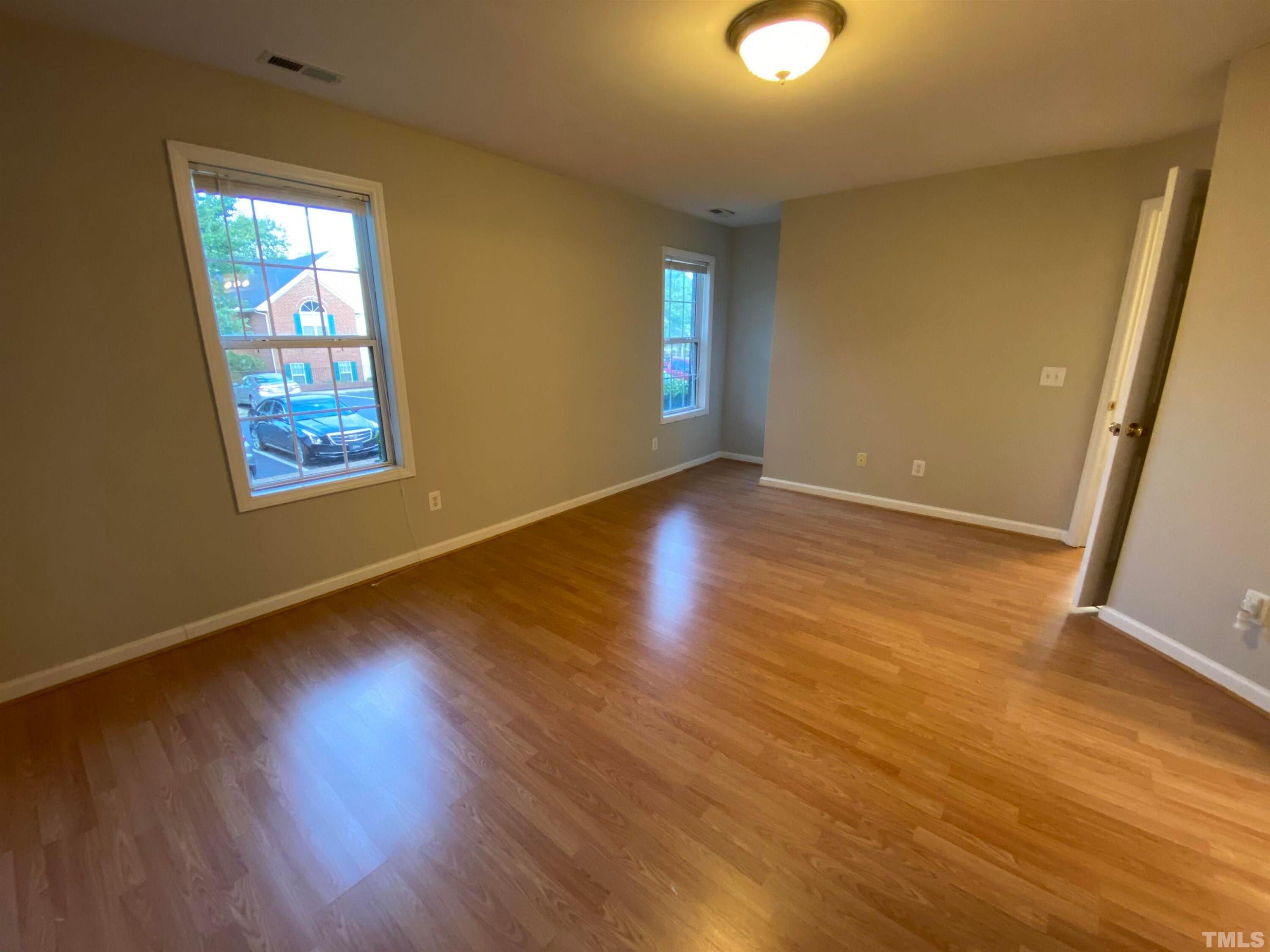 2413 Wellington Ridge Loop, Unit 2413 Cary, NC 27518 - Photo 25 of 30 a view of an empty room with wooden floor and a window