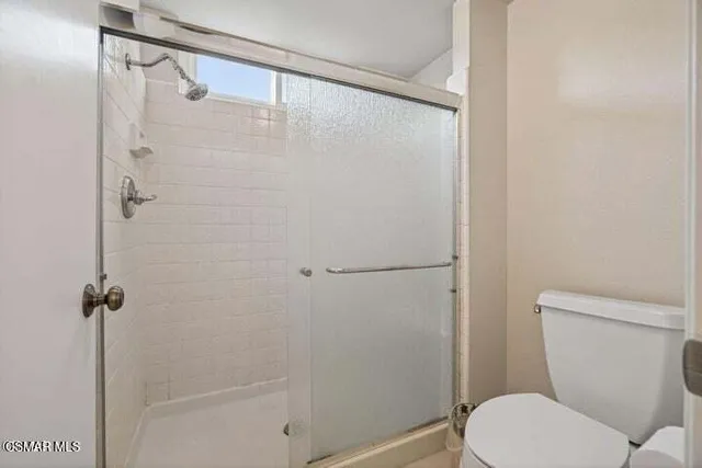 a white toilet sitting next to a shower