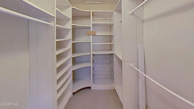 a view of walk in closet with empty racks