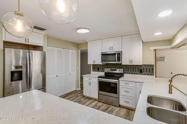 a kitchen with stainless steel appliances a stove sink microwave and refrigerator