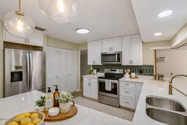 a kitchen with stainless steel appliances granite countertop a refrigerator and a stove top oven