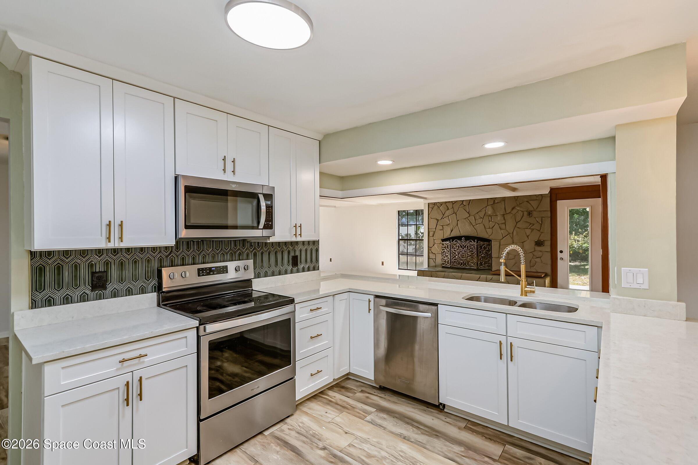 1275 Troon Way Rockledge, FL 32955 - Photo 4 of 61 a kitchen with white cabinets and white appliances