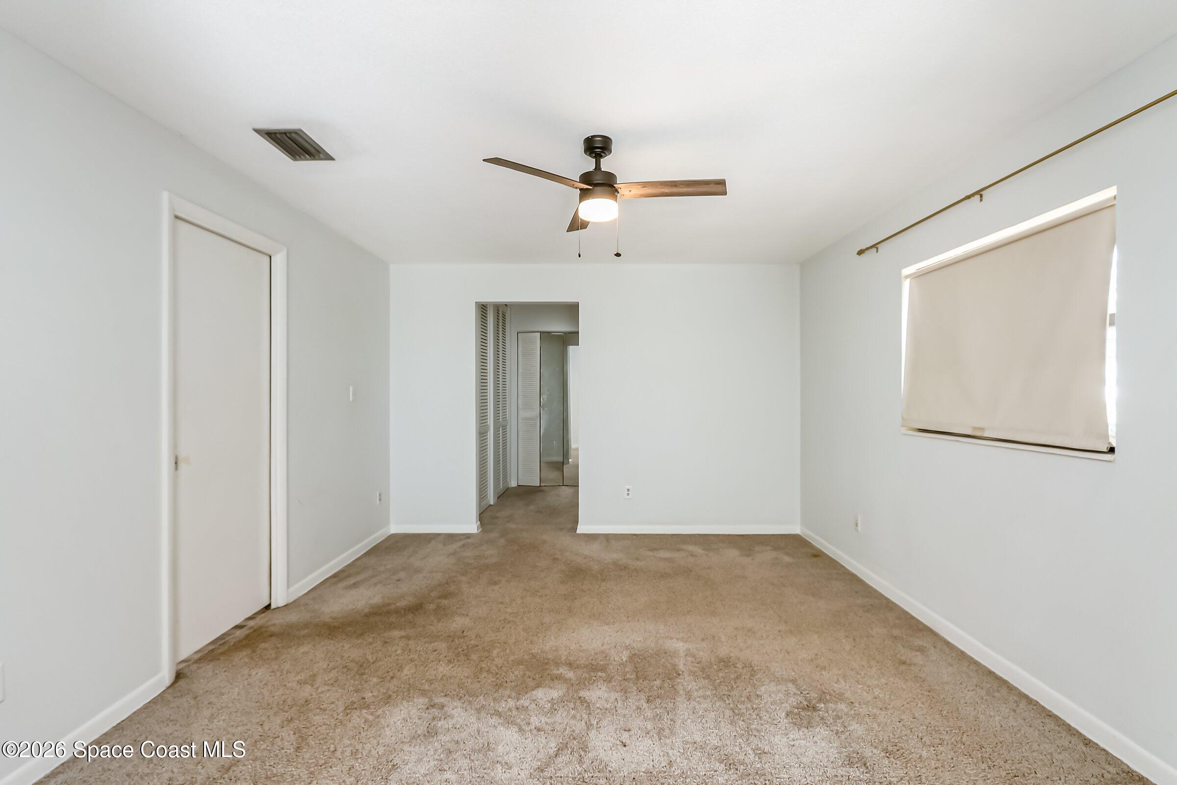 1275 Troon Way Rockledge, FL 32955 - Photo 41 of 61 an empty room with a ceiling fan and a window