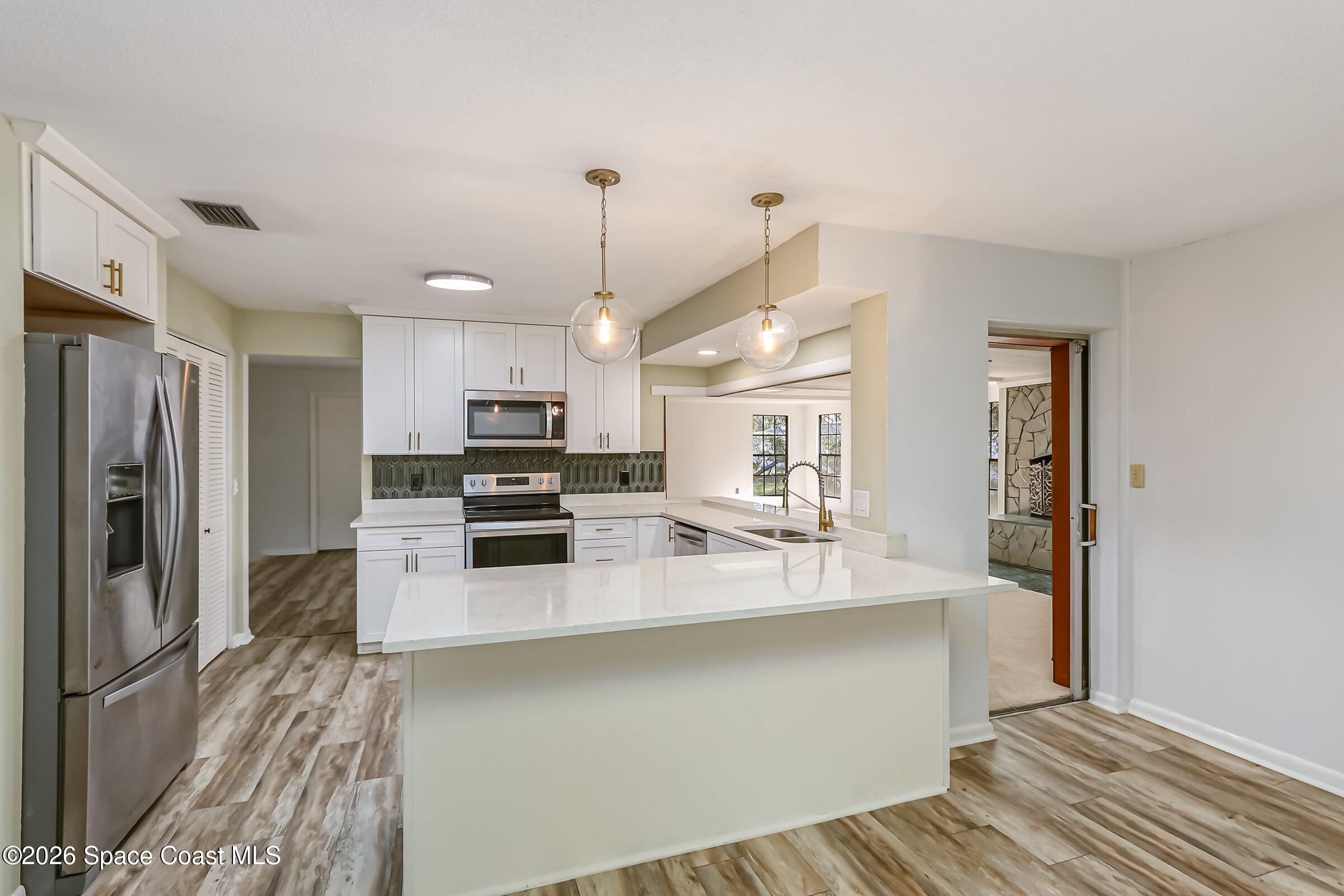 1275 Troon Way Rockledge, FL 32955 - Photo 5 of 61 a kitchen with stainless steel appliances a refrigerator sink and stove