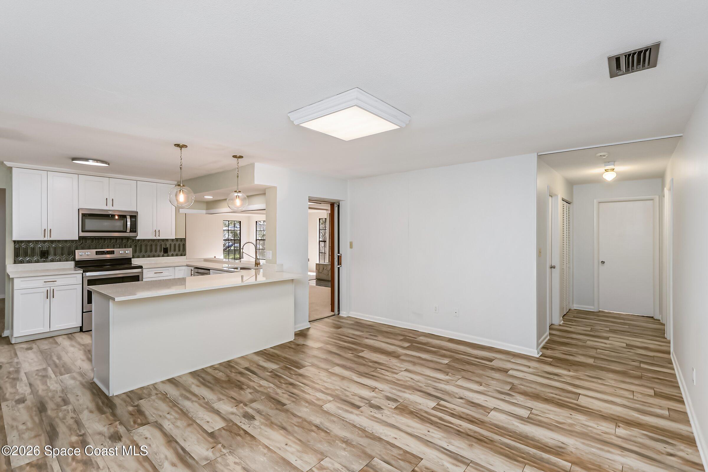 1275 Troon Way Rockledge, FL 32955 - Photo 6 of 61 a kitchen with stainless steel appliances granite countertop a refrigerator and a stove top oven