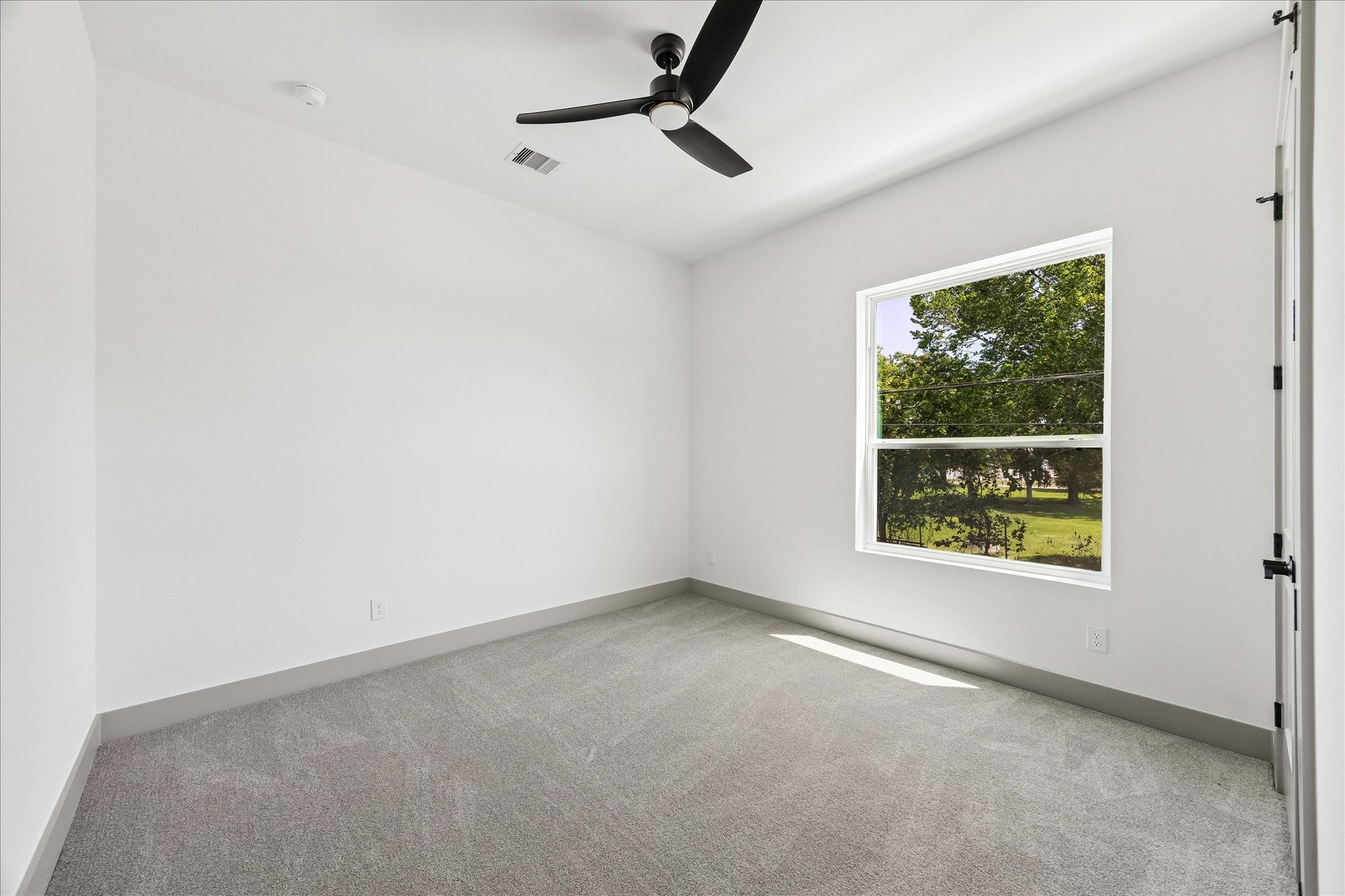 2953 Delafield Street Houston, TX 77023 - Photo 7 of 22 Privately positioned on the main living level, this secondary bedroom offers exceptional flexibility as a guest suite, home office, or quiet retreat.