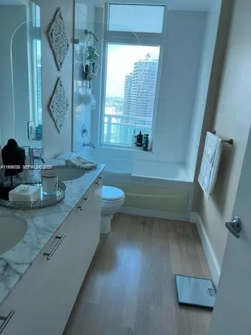 a bathroom with a granite countertop sink a toilet and a bathtub