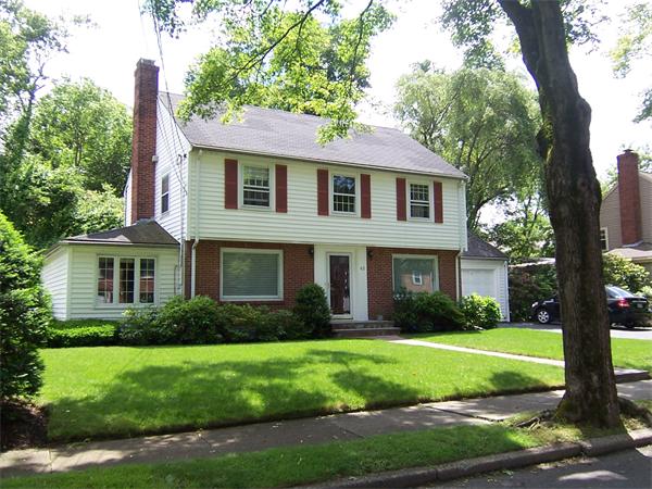 a front view of a house with a garden and yard