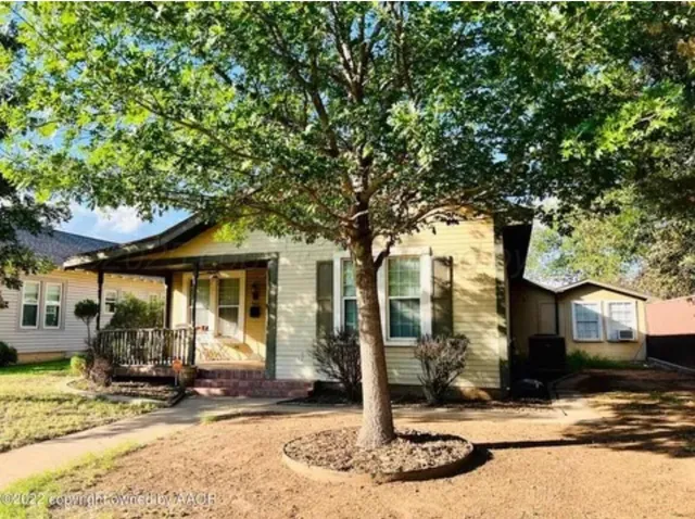 a front view of a house with a tree