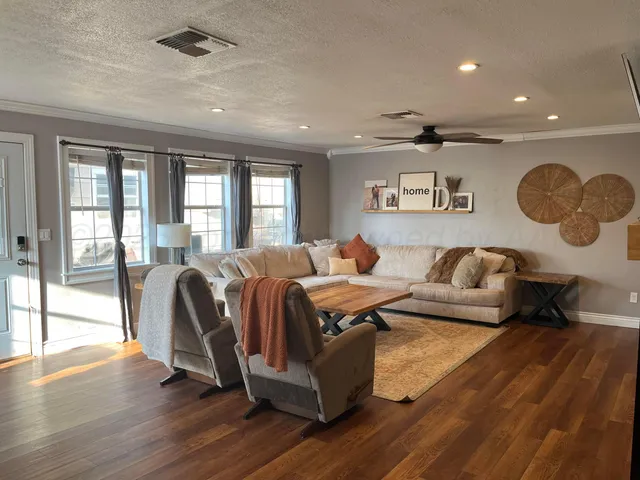 a living room with furniture and wooden floor