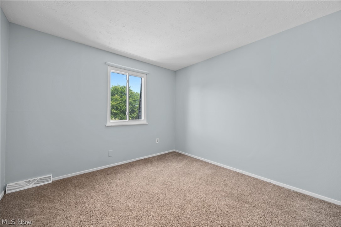 216 Moore Road Avon Lake, OH 44012 - Photo 15 of 22 Neutral wall paint, plush carpet flooring, white trim, and a window with natural light