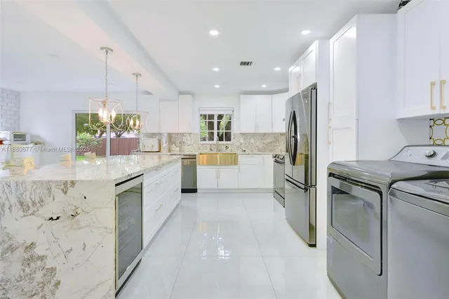 a kitchen with a sink window and stainless steel appliances
