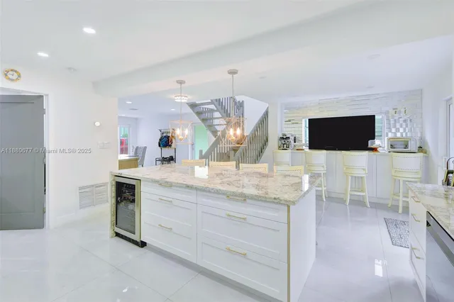 a kitchen with stainless steel appliances kitchen island granite countertop a stove and a sink