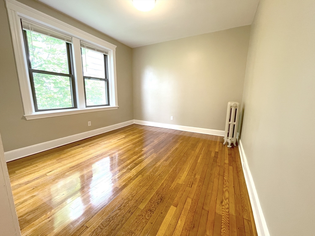 660 Huntington Avenue, Unit 58 Boston, MA 02115 - Photo 1 of 19 a view of an empty room with wooden floor and a window