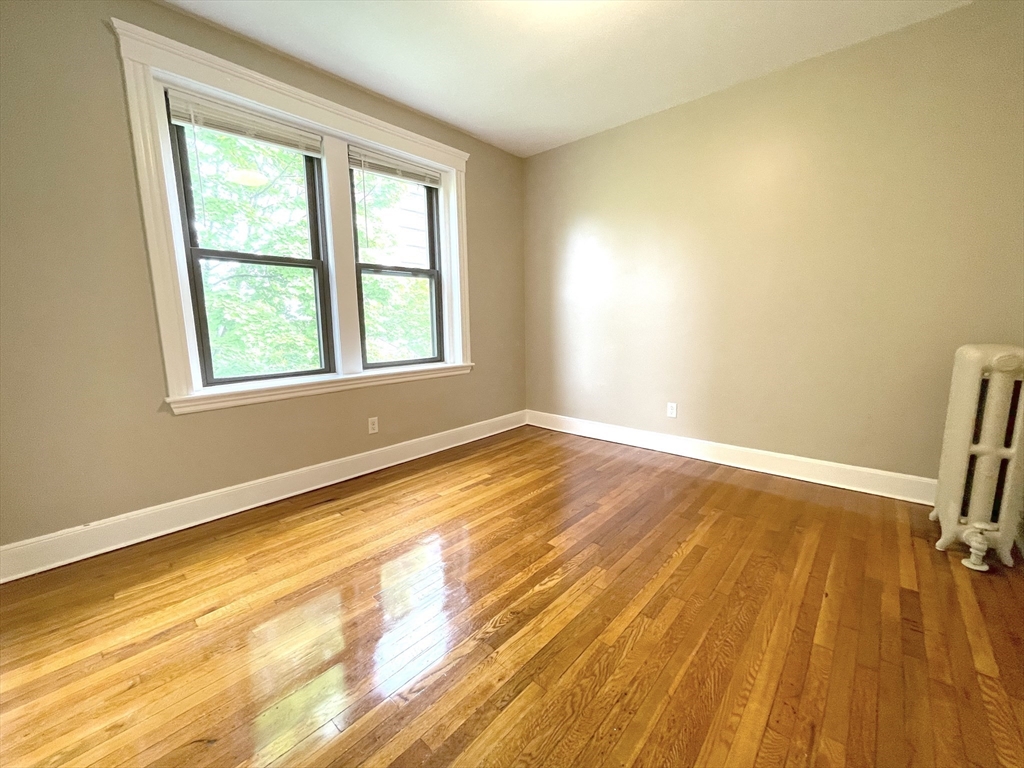 660 Huntington Avenue, Unit 58 Boston, MA 02115 - Photo 3 of 19 a view of an empty room with a window and wooden floor