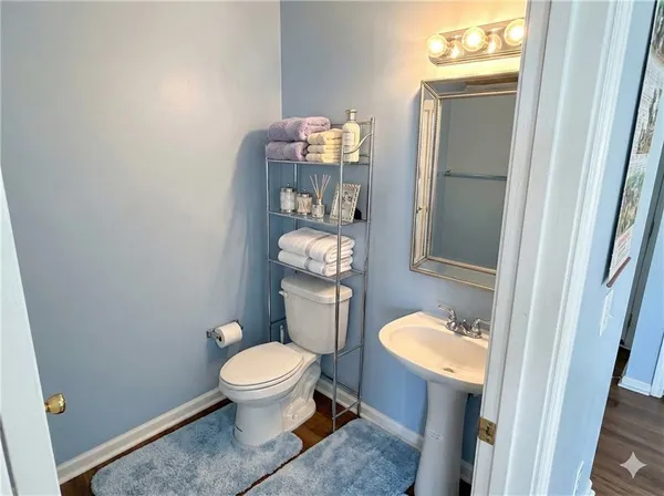 a bathroom with a toilet a sink and a mirror