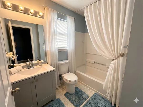 a bathroom with a sink a toilet and tub with mirror