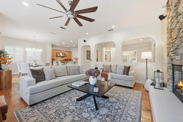 a living room with furniture wooden floor and a chandelier