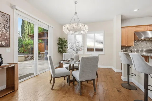 a dining room with furniture a chandelier and wooden floor