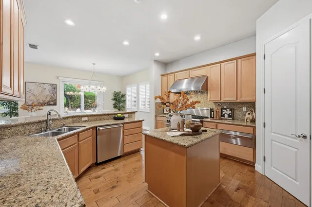 a kitchen with kitchen island granite countertop a sink appliances cabinets and counter space