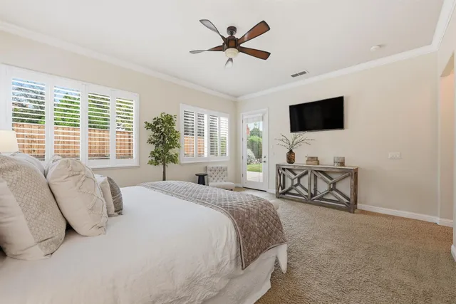 a spacious bedroom with a bed and a flat screen tv
