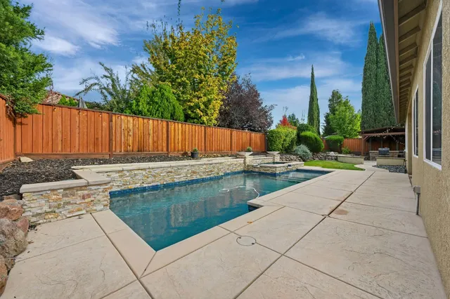 a view of swimming pool with outdoor seating and plants