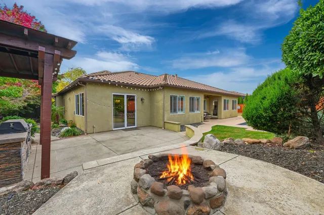 a view of a house with a yard and sitting area