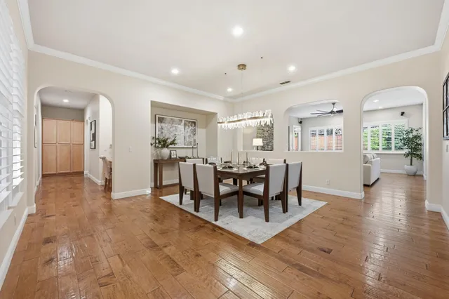 a view of a dining room and livingroom with furniture wooden floor a chandelier