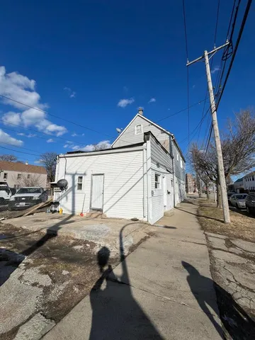 a white building with a large window and car parked