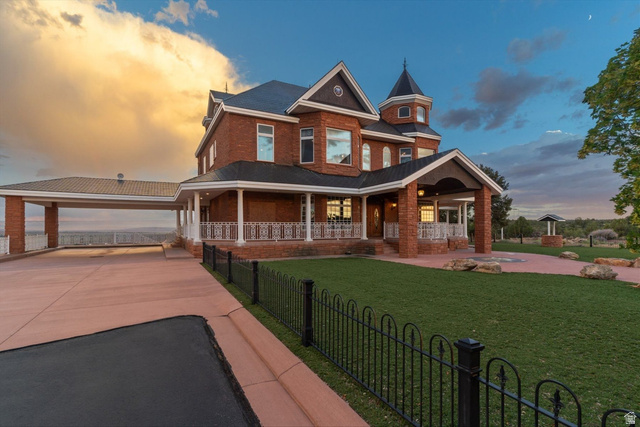 5615 East Eight Mile Gap Road Kanab, UT 84741 - Photo 67 of 81 View of front of property with a porch, a fenced front yard, brick siding, and driveway