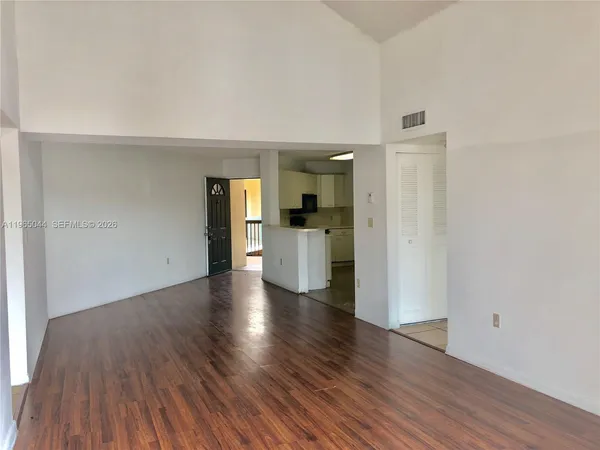 a view of a kitchen with wooden floor and a refrigerator