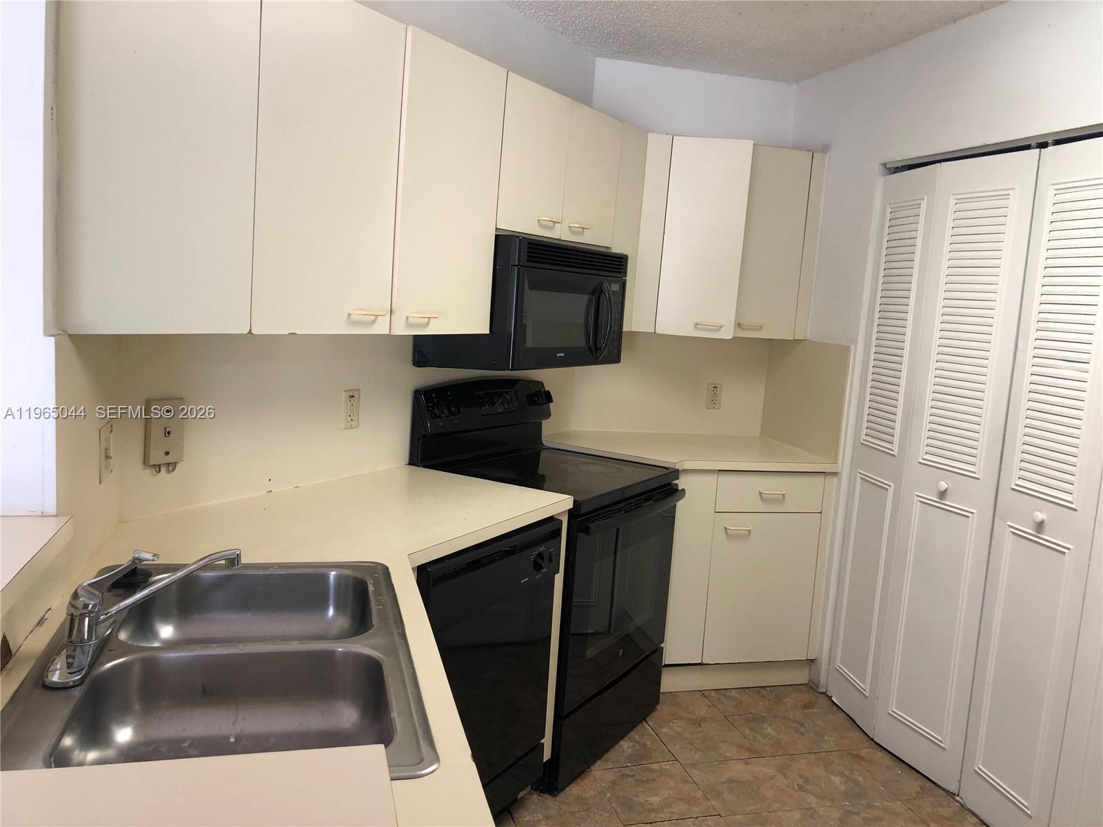 6280 Northwest 186th Street, Unit 311 Hialeah, FL 33015 - Photo 7 of 21 a kitchen with a sink a stove and a microwave
