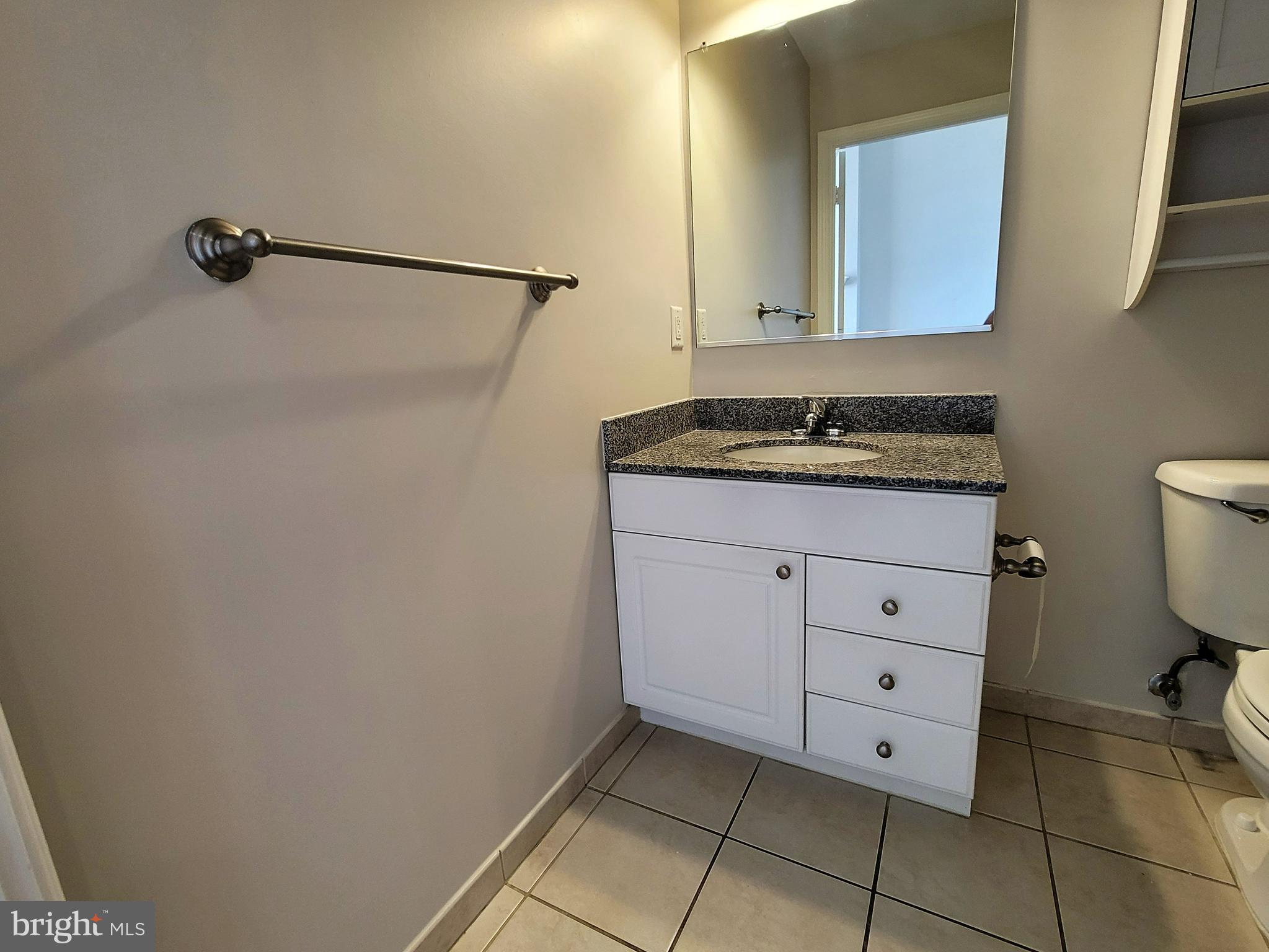 3600 South Glebe Road, Unit 602W Arlington, VA 22202 - Photo 27 of 46 a bathroom with a granite countertop sink a toilet and mirror