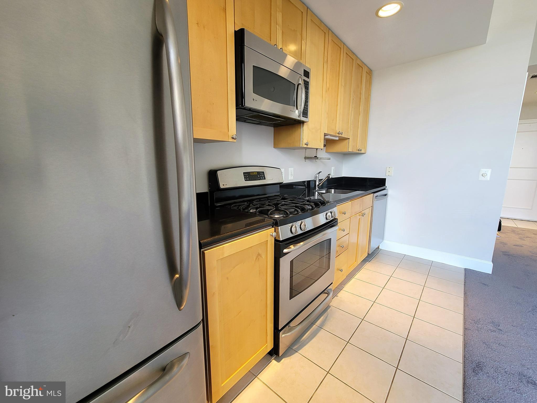 3600 South Glebe Road, Unit 602W Arlington, VA 22202 - Photo 36 of 46 a kitchen with stainless steel appliances granite countertop a stove a sink and a microwave