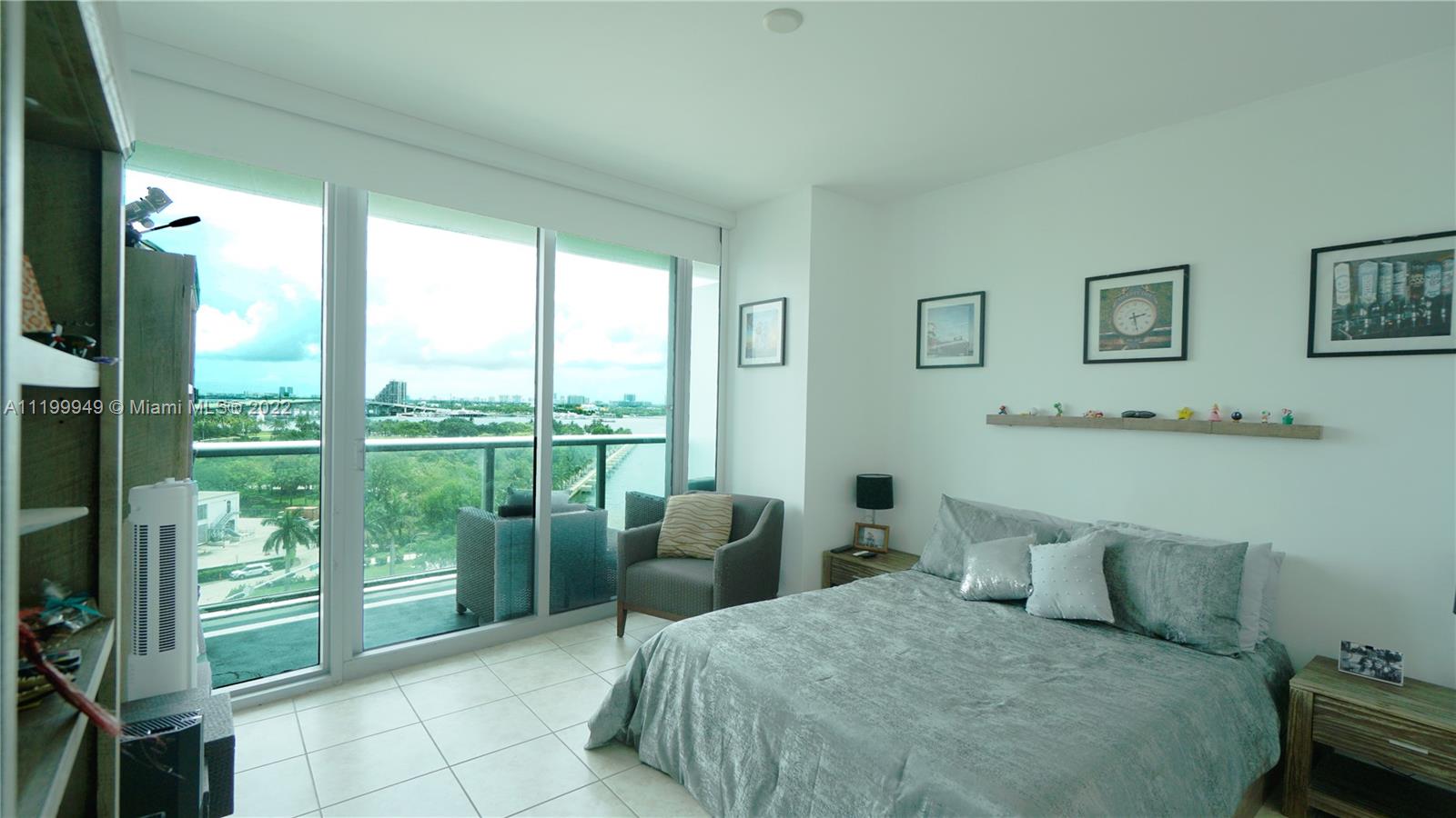 888 Biscayne Boulevard, Unit 811 Miami, FL 33132 - Photo 16 of 20 a bedroom with a bed and glass window
