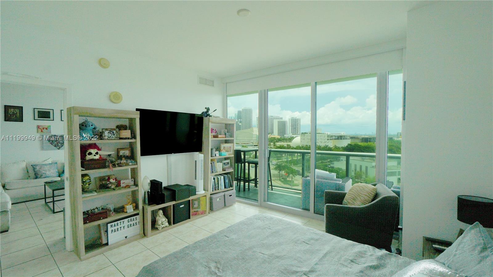 888 Biscayne Boulevard, Unit 811 Miami, FL 33132 - Photo 17 of 20 a living room with furniture a flat screen tv and a floor to ceiling window