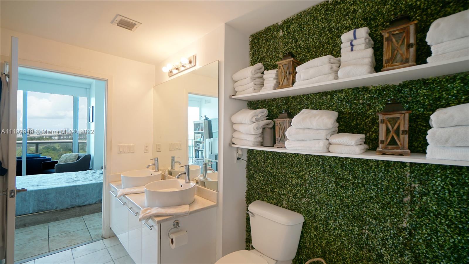 888 Biscayne Boulevard, Unit 811 Miami, FL 33132 - Photo 19 of 20 a bathroom with a toilet sink and mirror