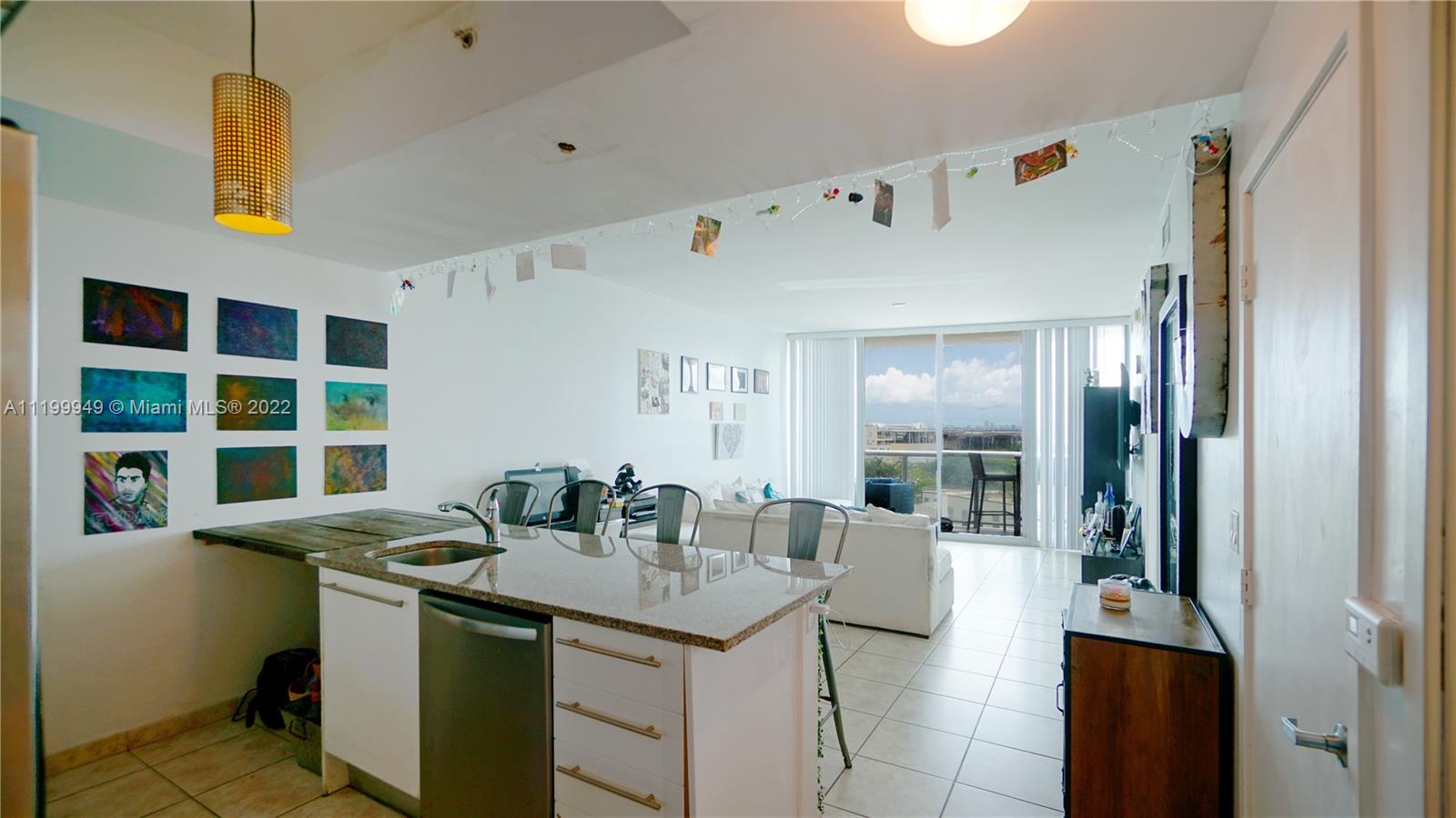 888 Biscayne Boulevard, Unit 811 Miami, FL 33132 - Photo 5 of 20 a view of a kitchen with a sink dishwasher stove and living room view