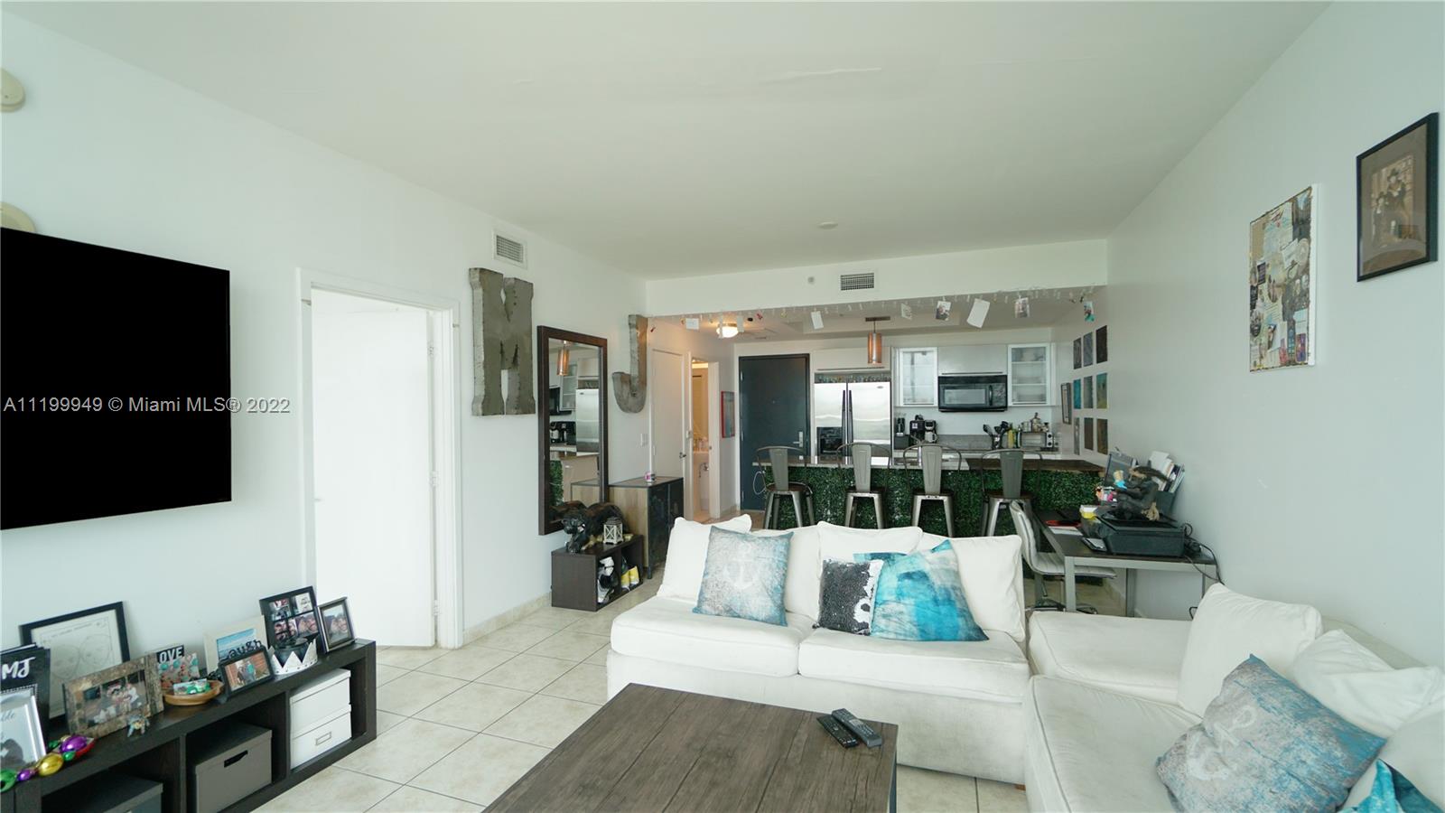 888 Biscayne Boulevard, Unit 811 Miami, FL 33132 - Photo 7 of 20 a living room with furniture and a flat screen tv