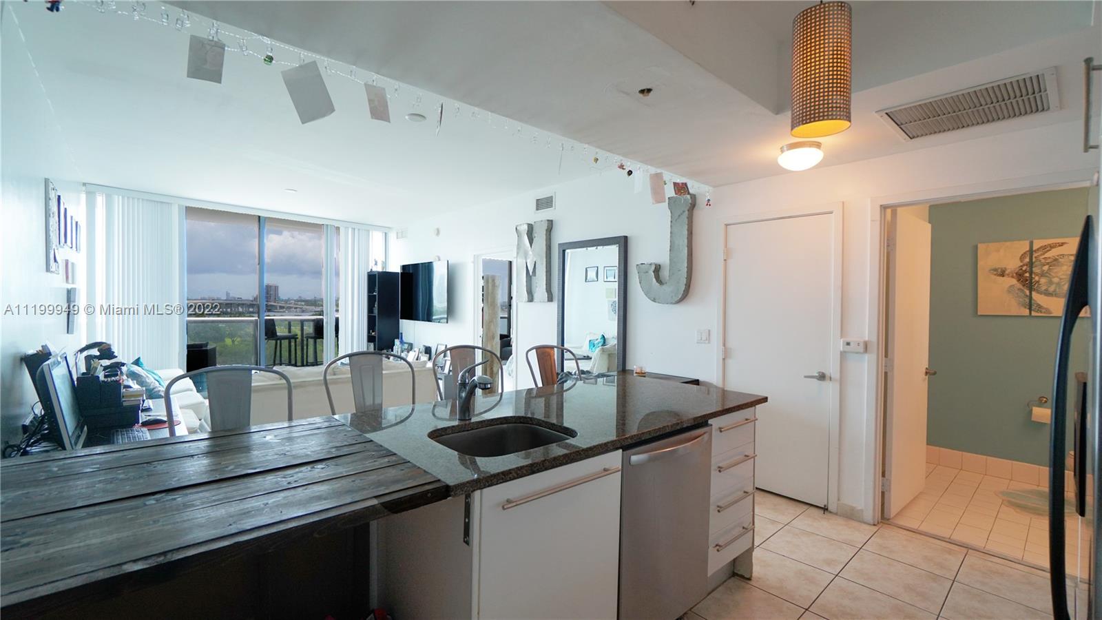 888 Biscayne Boulevard, Unit 811 Miami, FL 33132 - Photo 10 of 20 a kitchen with stainless steel appliances granite countertop a sink and cabinets
