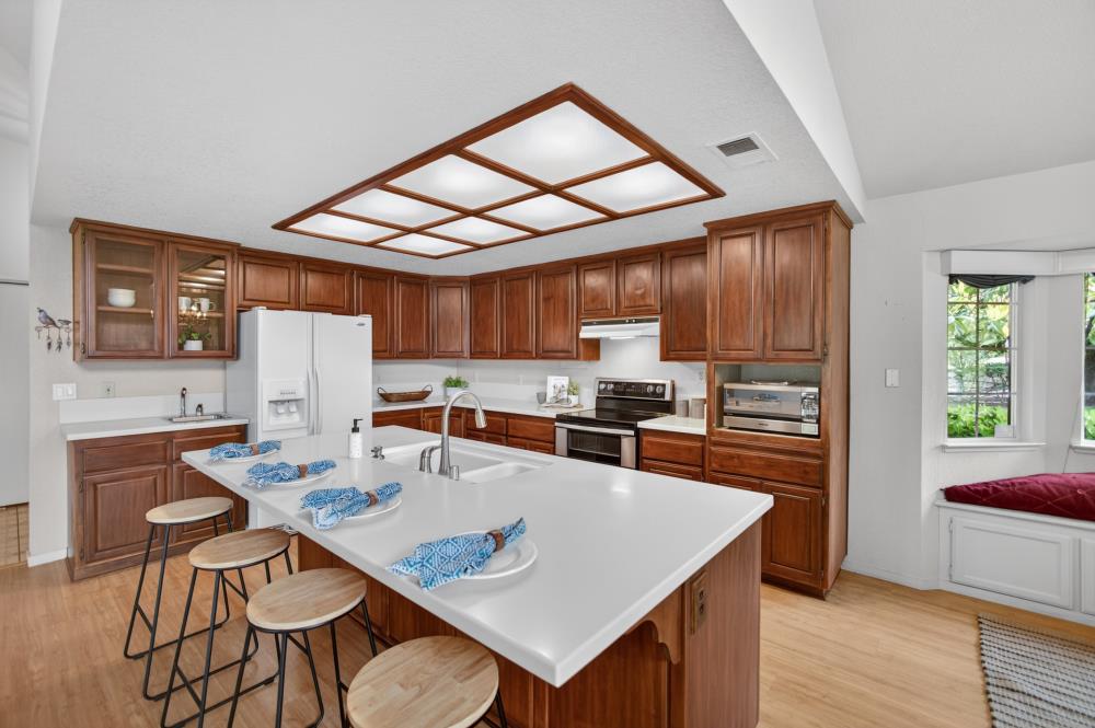 7649 El Modena Avenue Elverta, CA 95626 - Photo 17 of 75 a kitchen with stainless steel appliances kitchen island granite countertop a refrigerator a stove top oven a sink dishwasher and white countertops with wooden floor