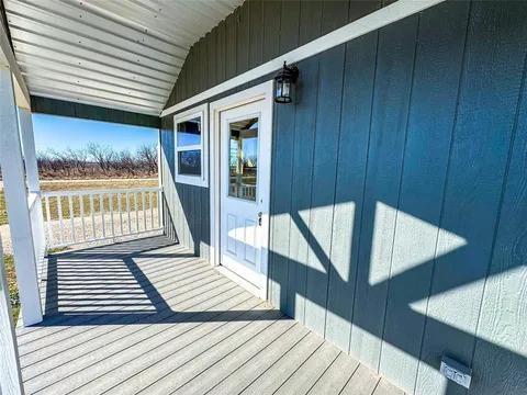 323 Blue Cat Boulevard Haskell, TX 79521 - Photo 13 of 18 Covered front porch featuring durable composite decking, white railing, and a corrugated metal ceiling