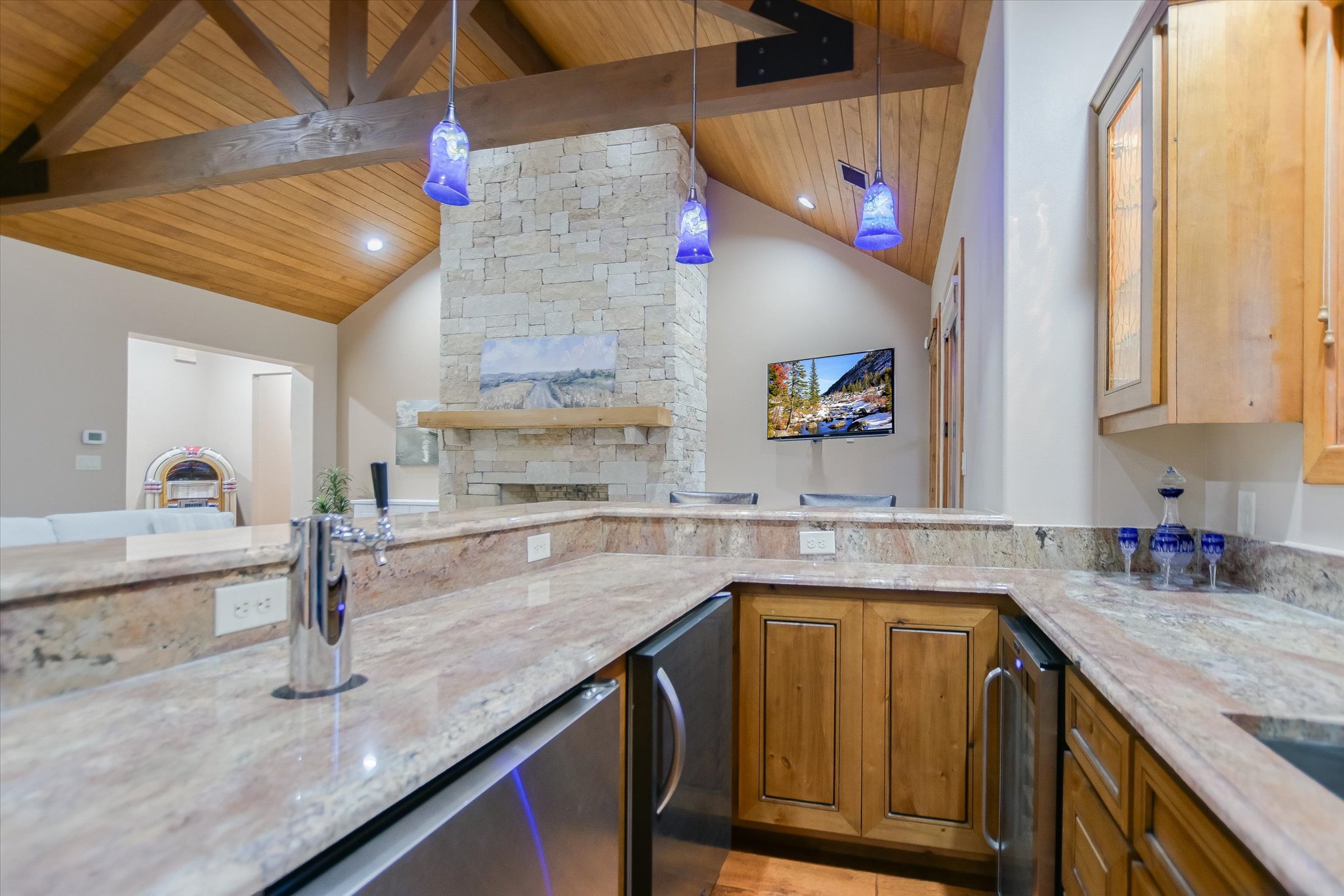 409 Venture Boulevard South Point Venture, TX 78645 - Photo 12 of 37 U-shaped wet bar featuring granite countertops, under-counter refrigeration, and custom wood cabinetry