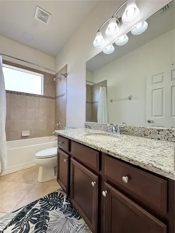 a bathroom with a granite countertop toilet a sink and a bathtub
