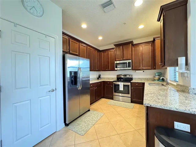 a kitchen with granite countertop stainless steel appliances cabinets a sink and a counter top space