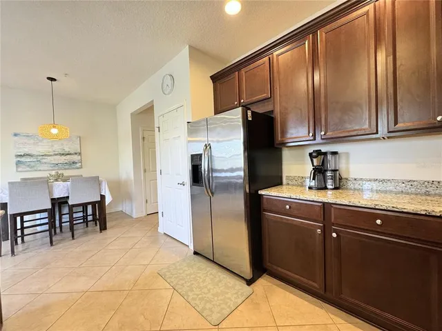 a kitchen with granite countertop a refrigerator and cabinets
